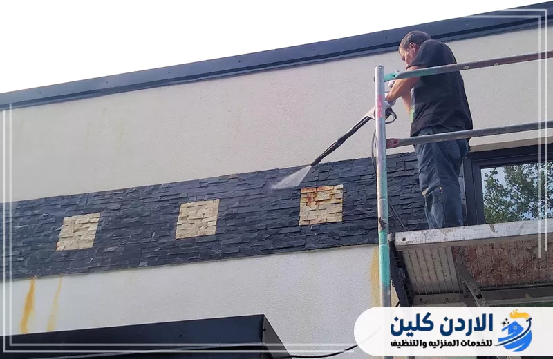 تنظيف كسوة واجهة مبنى مرتفعة بالمياه لإزالة البقع وتحسين مظهر الألواح.