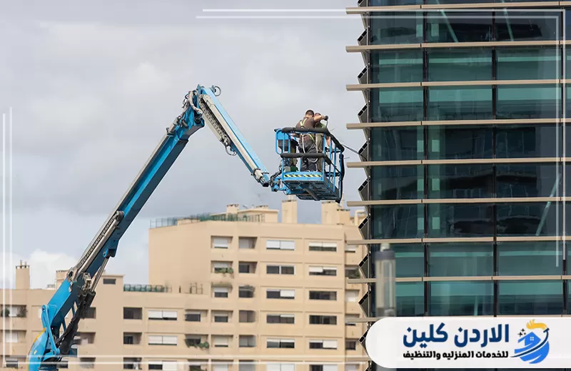 اتصل على 0798779667 لتنظيف نوافذ المباني. تنظيف النوافذ الخارجية لمبنى تجاري باستخدام رافعة للوصول إلى الأدوار المرتفعة بصورة منظمة.