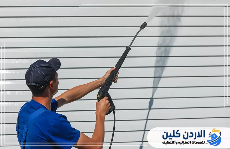 عامل ينظف ألواح واجهة خارجية لإزالة الغبار والرواسب المتراكمة.