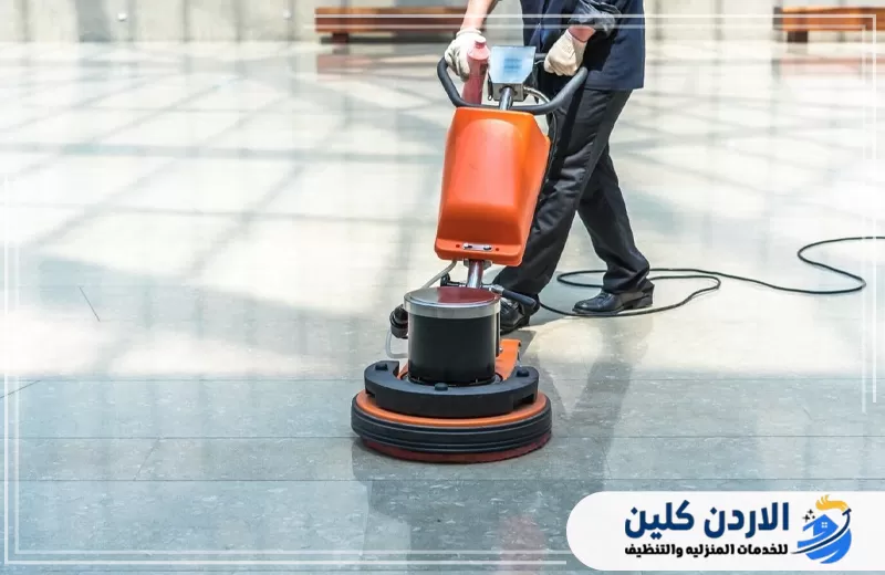 عامل يستخدم ماكينة جلي وتلميع احترافية لتنظيف الأرضيات وإزالة البهتان واستعادة اللمعان داخل المساحات الواسعة.