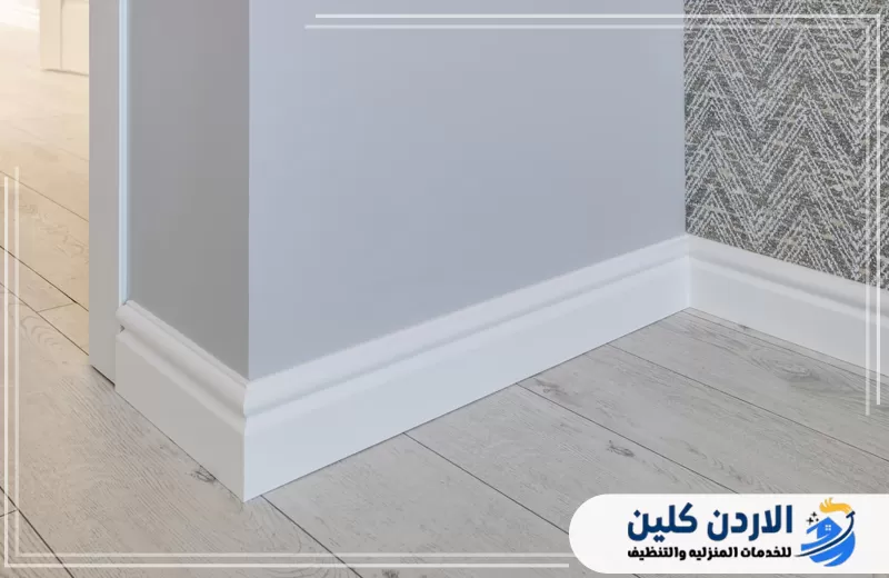 وزرات أرضيات بيضاء مثبتة عند التقاء الجدار بالأرضية لإخفاء الحواف وإكمال التشطيب الداخلي للمكان.