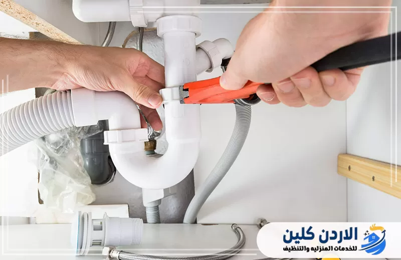 فني ينفذ صيانة سباكة المطبخ أسفل الحوض مع شد الوصلات وفحص ماسورة الصرف وإصلاح نقاط التسرب.