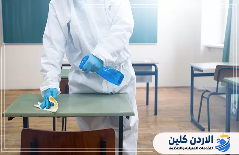 تنفيذ تعقيم لطاولة داخل فصل أو حضانة مع التركيز على الأسطح التي تتكرر ملامستها يوميًا.