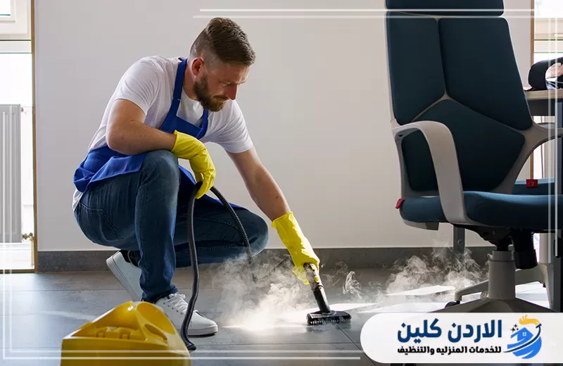 عامل يستخدم جهاز البخار لتنظيف أرضيات المكتب والزوايا ضمن خدمة تنظيف مكاتب في الأردن.