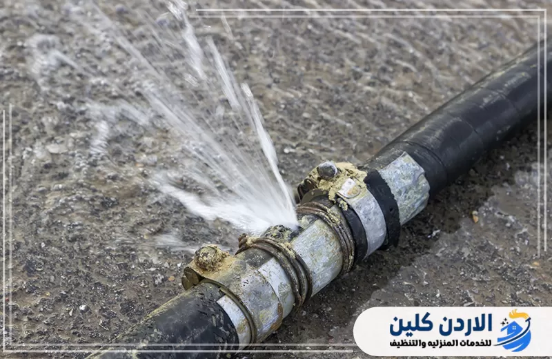 ماسورة مياه خارجية متضررة تتسبب في اندفاع الماء من منطقة الوصلة بشكل قوي.