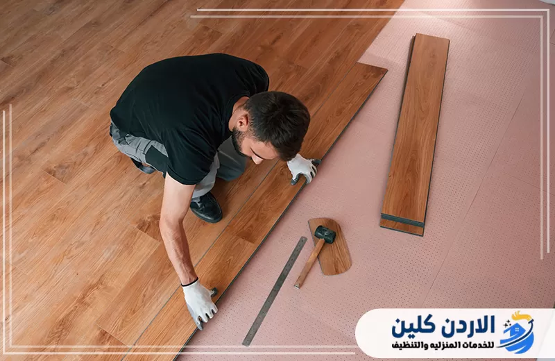 فني يقوم بضبط وتركيب ألواح الباركيه بعناية ضمن أعمال صيانة وتصليح الباركيه في الأردن لتحسين الشكل النهائي للأرضية.