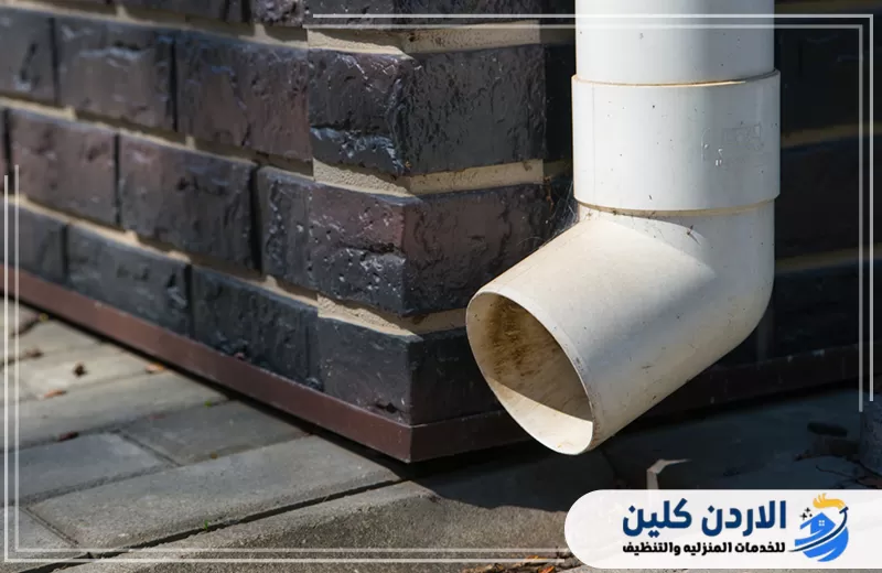 تواصل معنا لصيانة مواسير ومخارج صرف الأمطار 0798779667. ماسورة PVC لتصريف مياه الأمطار مثبتة بجانب الجدار لتوجيه المياه بعيدًا عن المبنى.