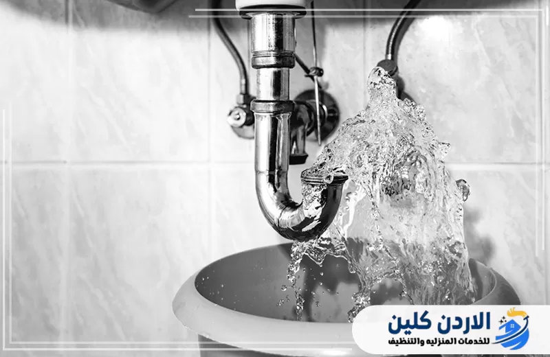 ماسورة صرف معدنية أسفل المغسلة تتسرب منها المياه بغزارة مع وضع وعاء لتجميع الماء.