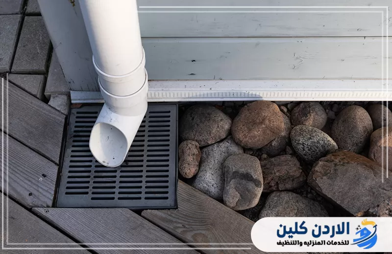 اطلب فحص نظام صرف الأمطار والمزاريب الآن 0798779667. مخرج صرف أمطار أبيض يصب المياه في فتحة تصريف أرضية لحماية الأرضية المحيطة من التجمعات.