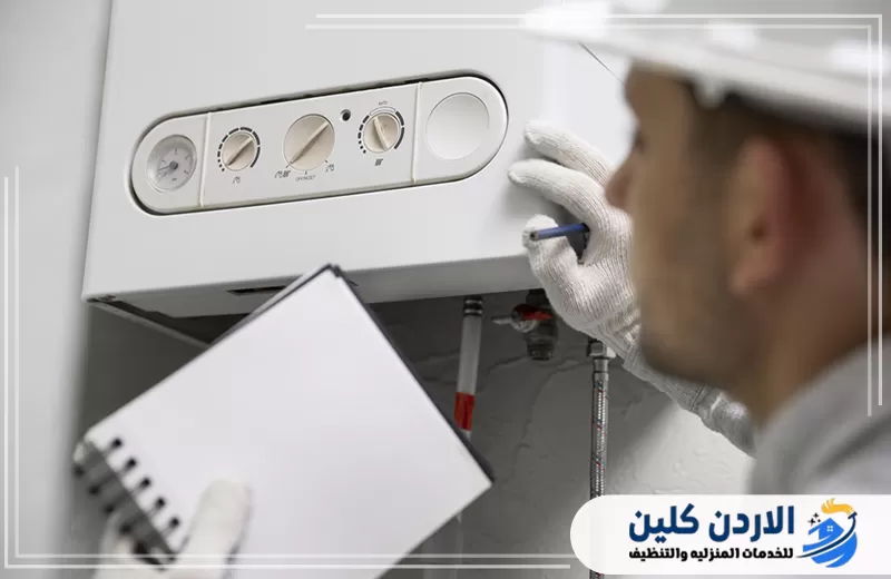 فني يفحص سخان المياه ويعاين لوحة التحكم للتأكد من سلامة التشغيل وكفاءة الأداء.