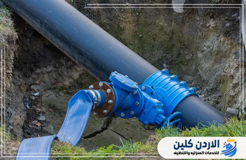 محبس أزرق مركب على خط مياه أسود داخل حفرة لتسهيل التحكم في التدفق وعزل أجزاء الشبكة عند الصيانة.