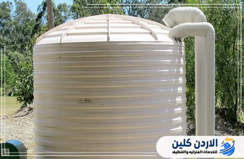 احجز فحص نظام الخزان والمضخة لضمان تدفق المياه 0798779667. خزان مياه أبيض مزود بمواسير كبيرة ضمن نظام تخزين وضخ المياه.