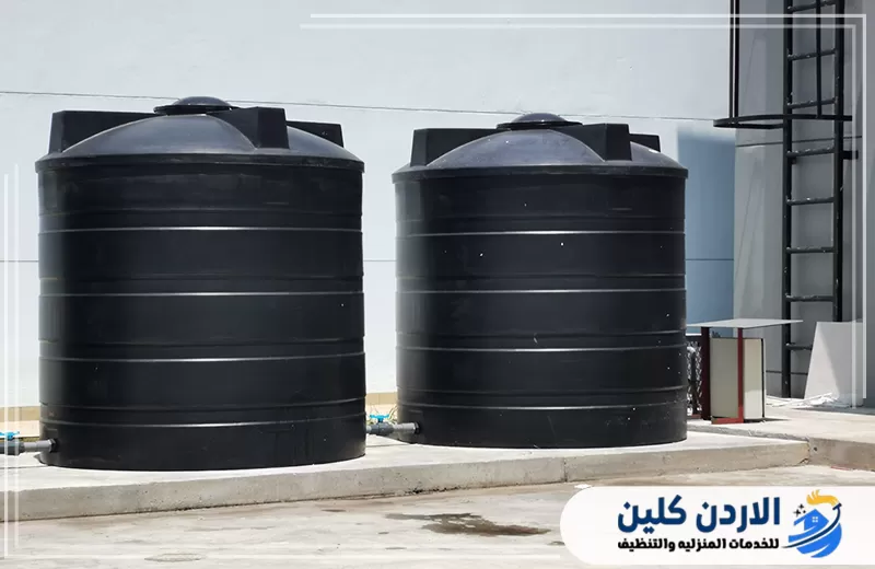 اطلب صيانة الخزانات وإصلاح التسربات من الأردن كلين 0798779667. خزانان أسودان مثبتان على قاعدة خرسانية ومتصلان بخطوط المياه الخارجية.