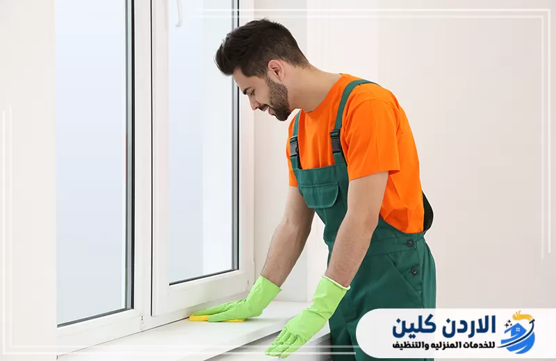 فني ينظف حافة النافذة والإطار السفلي لإزالة الأتربة من الزوايا والأماكن الدقيقة.