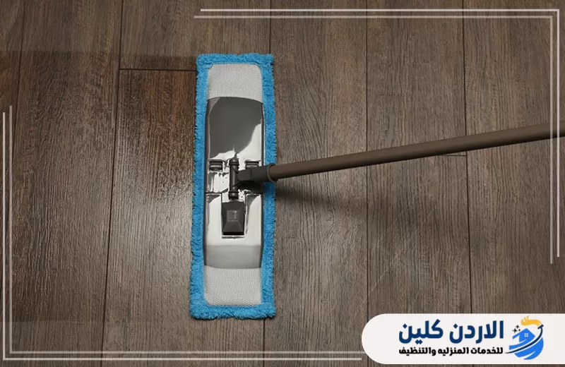 تنظيف أرضية خشبية بممسحة مسطحة للوصول إلى نظافة متجانسة وإزالة آثار الاستخدام اليومي.
